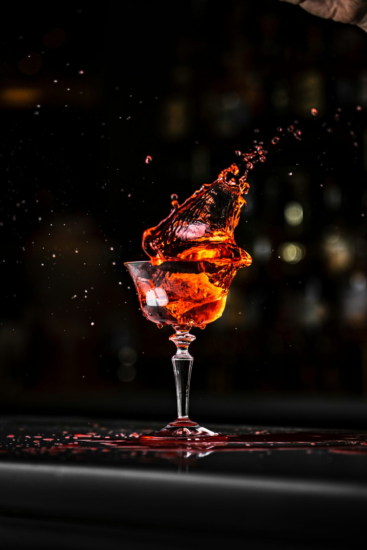 A cocktail lit amber against a dark lounge, without people